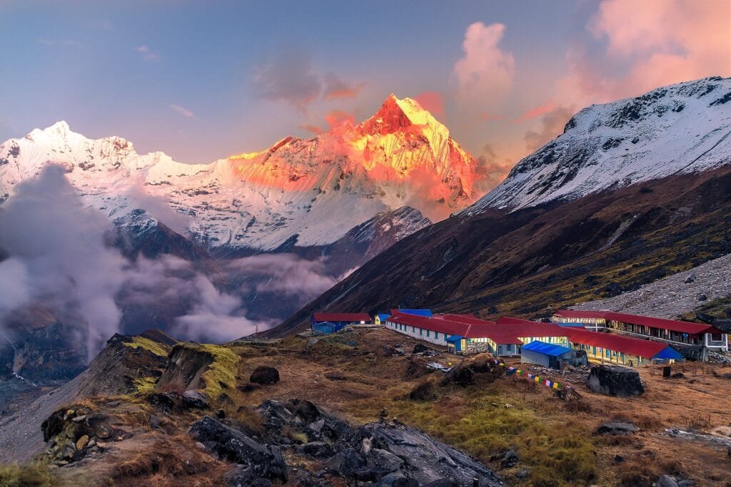 Snowy Himalayan peaks glow at sunrise near Annapurna Base Camp.