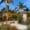 Tropical beachfront bungalow with hammock and palm trees at sunset