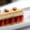 Elegant French dessert featuring a mille-feuille layered with puff pastry, vanilla cream, and fresh strawberries, garnished with glazed nuts and served with a scoop of pink sorbet on a white plate.