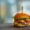Close-up of a gourmet cheeseburger with lettuce and tomato on a wooden surface