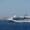 Luxurious white cruise ship sailing near coastal destination