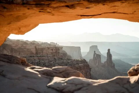 Top 10 Best Places to Visit in the USA Right Now 46 Sunrise view through a sandstone arch in Canyonlands National Park, Utah, USA.