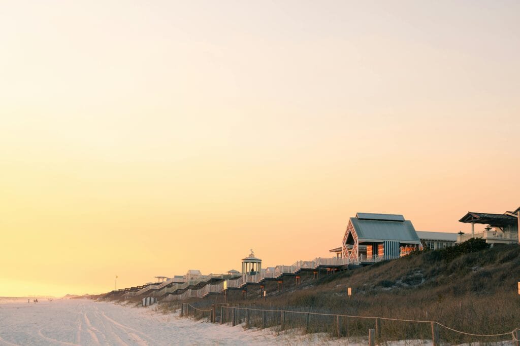 Best Beaches in Florida to Explore in 2025 4 Colorful beach houses along Destin Beach, Florida, during sunset with golden sky and soft white sand.
