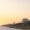 Colorful beach houses along Destin Beach, Florida, during sunset with golden sky and soft white sand.
