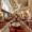 Elegant dining room of a London restaurant with classical statues, ornate ceilings, red leather chairs, and intricately tiled floors.