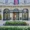 Alt text: Elegant entrance of the Mandarin Oriental Ritz Madrid featuring ornate iron gates, flags, and a uniformed doorman welcoming guests.