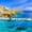 Vibrant coastal view of a harbor in Crete, Greece, featuring turquoise waters, anchored boats, a traditional wooden ship, and colorful hillside houses under a bright blue sky.