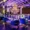 Luxurious interior of a Dallas nightclub featuring velvet lounge chairs, a grand chandelier, purple neon lighting, and a modern upscale ambiance.