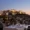 Elegant rooftop dining setup at sunset with a breathtaking illuminated view of the Acropolis in Athens, Greece, as seen from Electra Metropolis Hotel.
