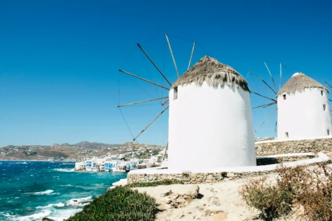 Iconic white windmills overlooking the sea in Mykonos, Greece.