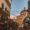 Bustling leather market at San Lorenzo in Florence, with colorful bags on display and historic architecture in the background.