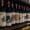 A row of Chianti Classico wine bottles from Casanuova di Nittardi displayed on a rustic wooden shelf in an Italian wine cellar.