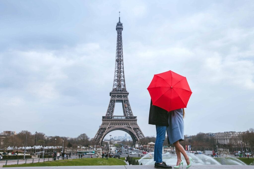 Couple with red umbrella near Eiffel Tower